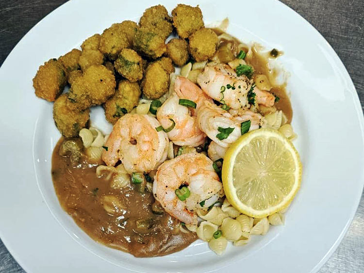 A delectable plate of shrimp Étouffée on mini shell pasta, accompanied by crispy fried okra. A mouthwatering seafood delight!