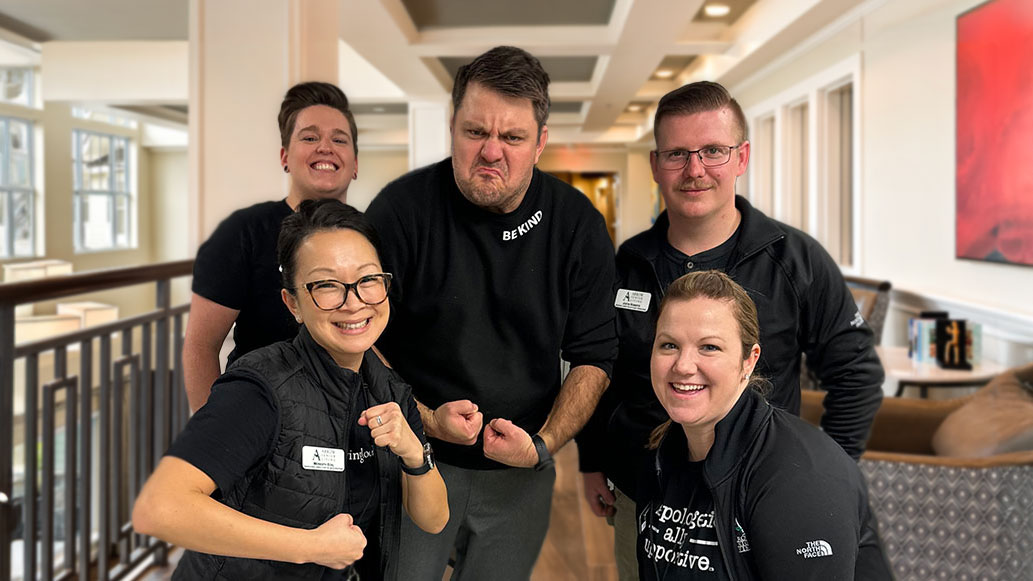 Arrow Senior Living team members pose together in a fun and energetic group shot, displaying camaraderie and teamwork as they prepare for a spring clean-up event.